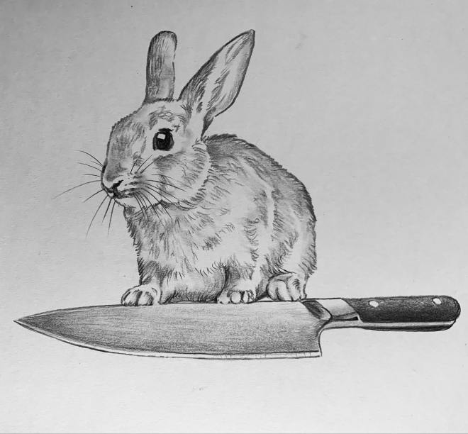 A bunny stands behind a chef's knife.